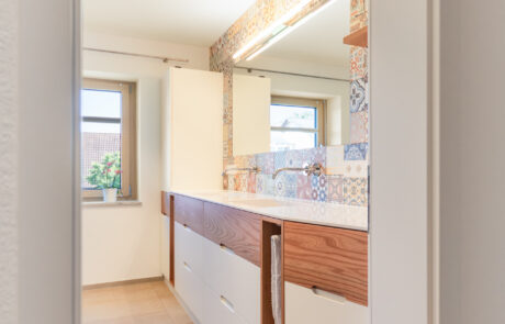 Badmöbel von der Schreinerei Häring mit Badschrank mit praktischen Funktionen für kleines Bad im Raum Emmendingen, Freiburg, Kaiserstuhl, March, Hugstetten, bis zum Boden mit weißem hellen Furnier und durchgehendes Echtholzfurnier mit großem Spiegel und hohem Schrank